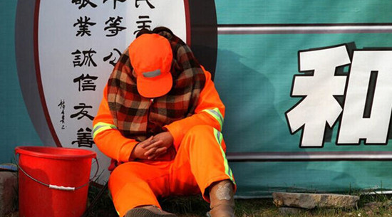 每天必須12小時在路面值守以時刻保持路面的清潔，環衛工人只能蜷縮在馬路啃饅頭、打瞌睡